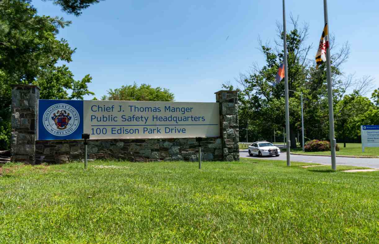 A Montgomery County, Md. police car passes the sign at the entrance to the Chief J. Thomas Manger Headquarters building in Gaithersburg.