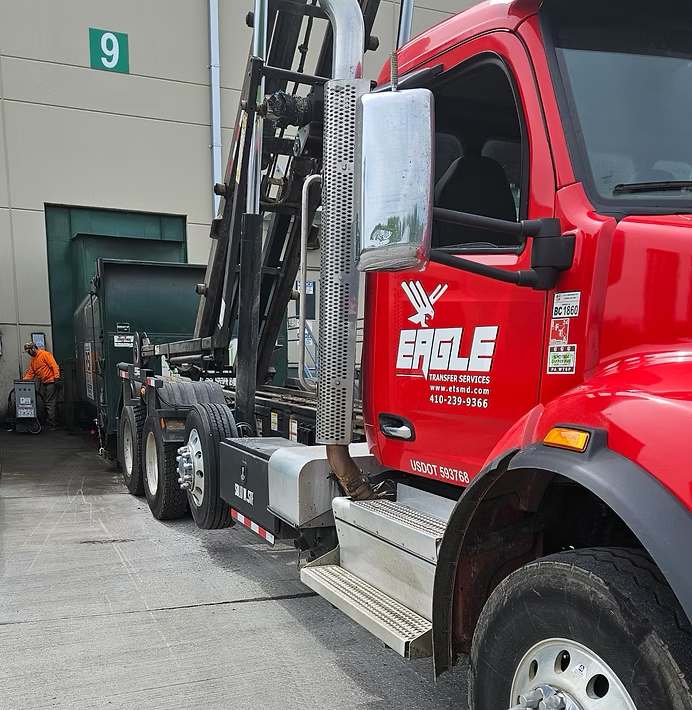 eagle transfer services red truck taking industrial waste from a commercial building