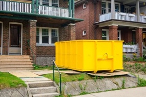 roll-off construction dumpster bright yellow outside a residential renovation project in an older neighourhood