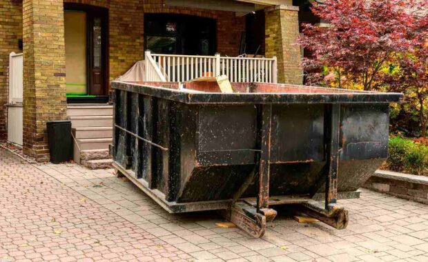 roll-off construction dumpster outside a residential renovation project in an older neighourhood. shot in toronto in the fall