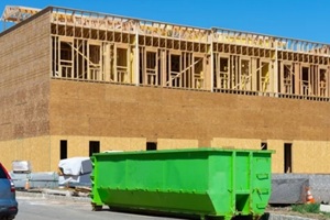 big green dumpster outside a big building