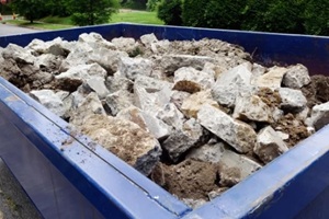 blue dumpster filled with stones during a construction