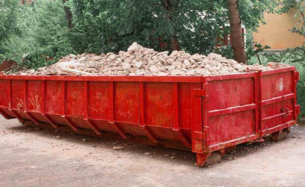 red container with solid domestic and construction waste