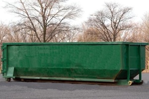 a big green dumpster outside a home