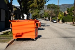 an orange dumpster in a road