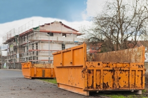 Grosse orange Container stehen vor einem Rohbau