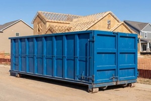 large blue roll-off dumpster at a residential construction site