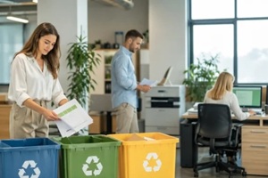 office workers sorting paper waste into recycling bins