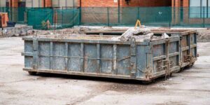 construction dumpster filled with debris at building site