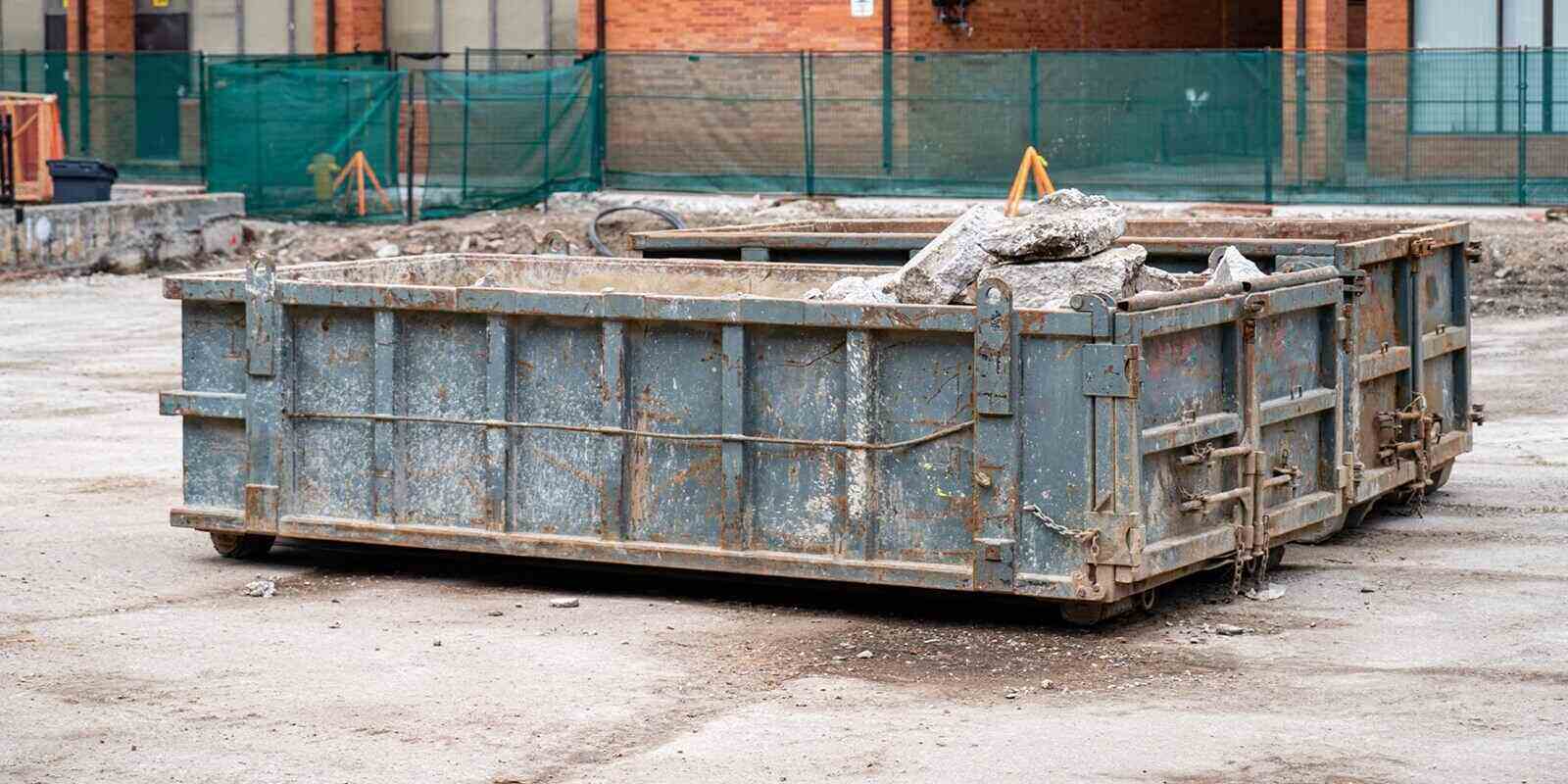 construction dumpster filled with debris at building site