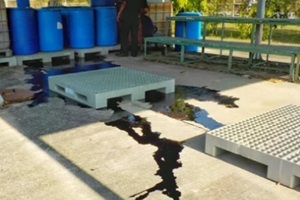 black liquid chemicals leaking from the tank into the floor