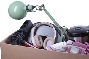 cardboard box full of different broken appliances for recycling isolated on white