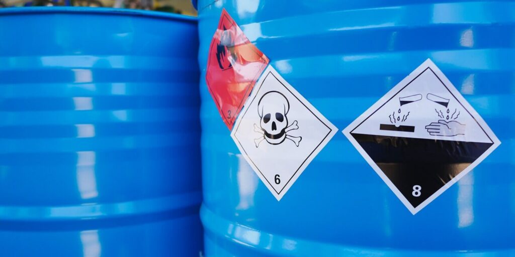 flammable, acid, volatile, warning labels, mounted on hazardous chemical storage tanks in the warehouse of a chemical industrial factory plant