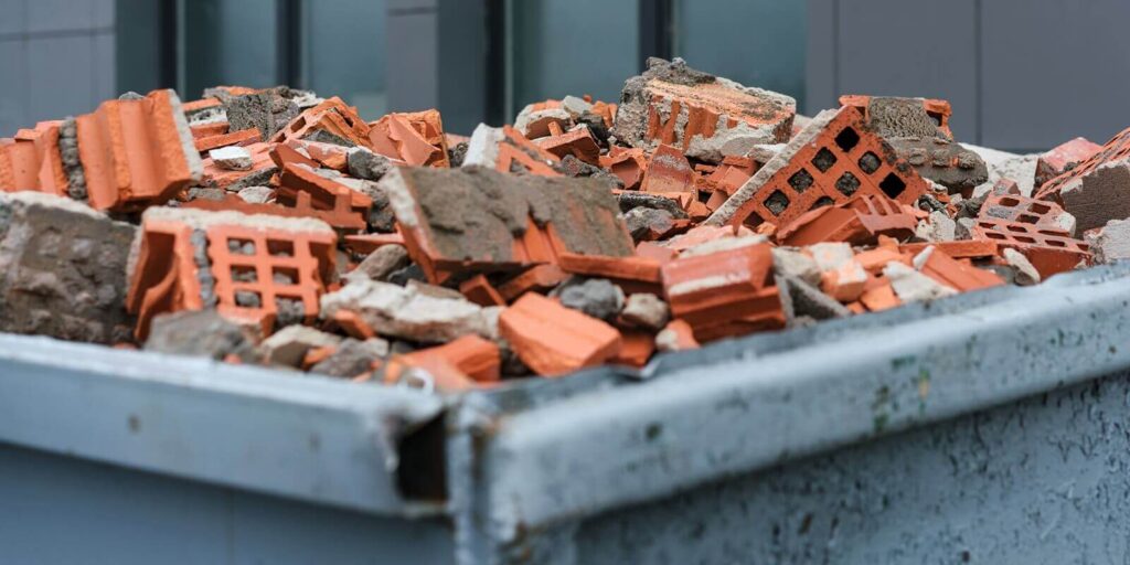 red bricks debris in construction metal waste container close up