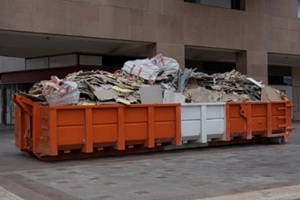 red dumpster with construction debris